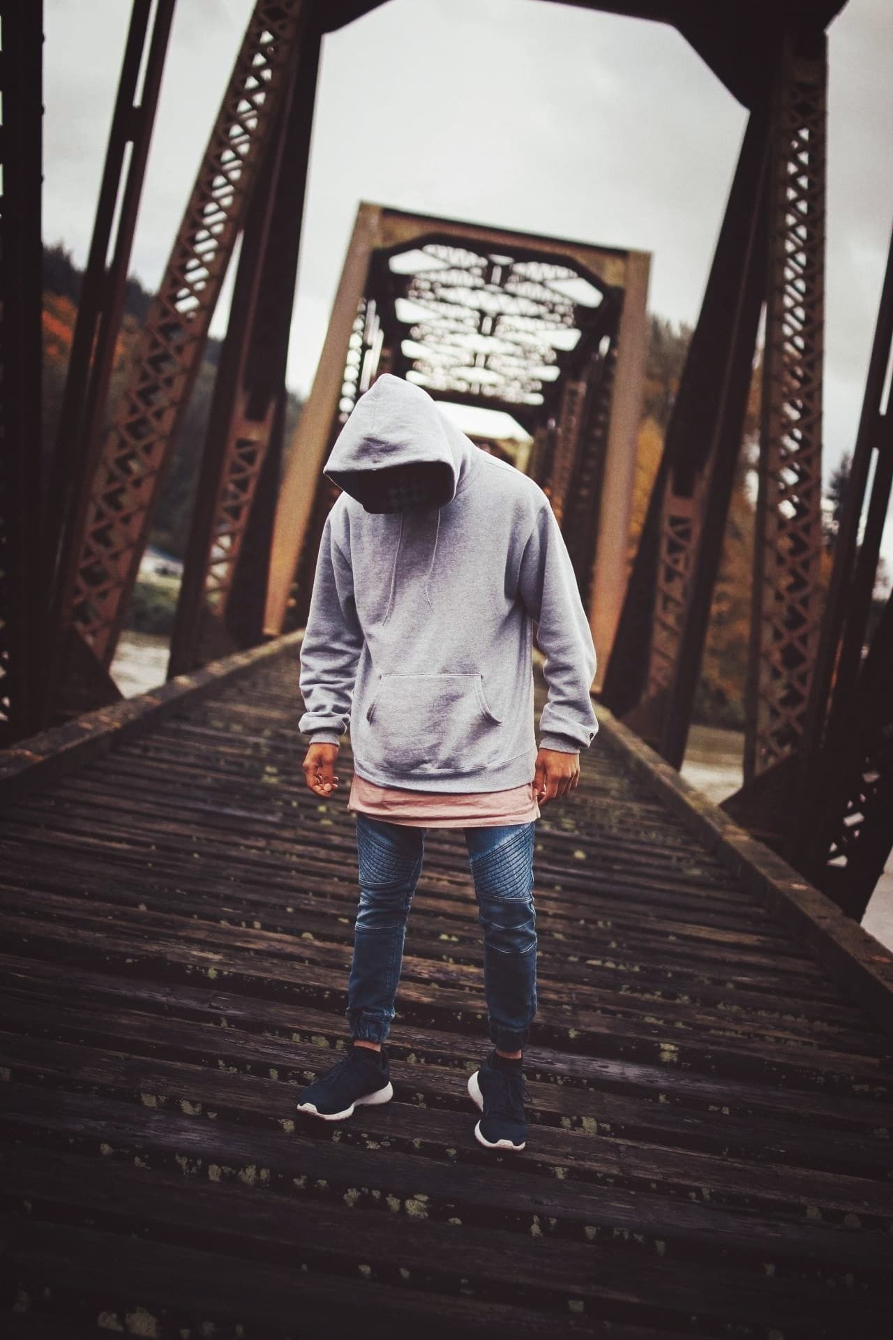 hooded figure on bridge